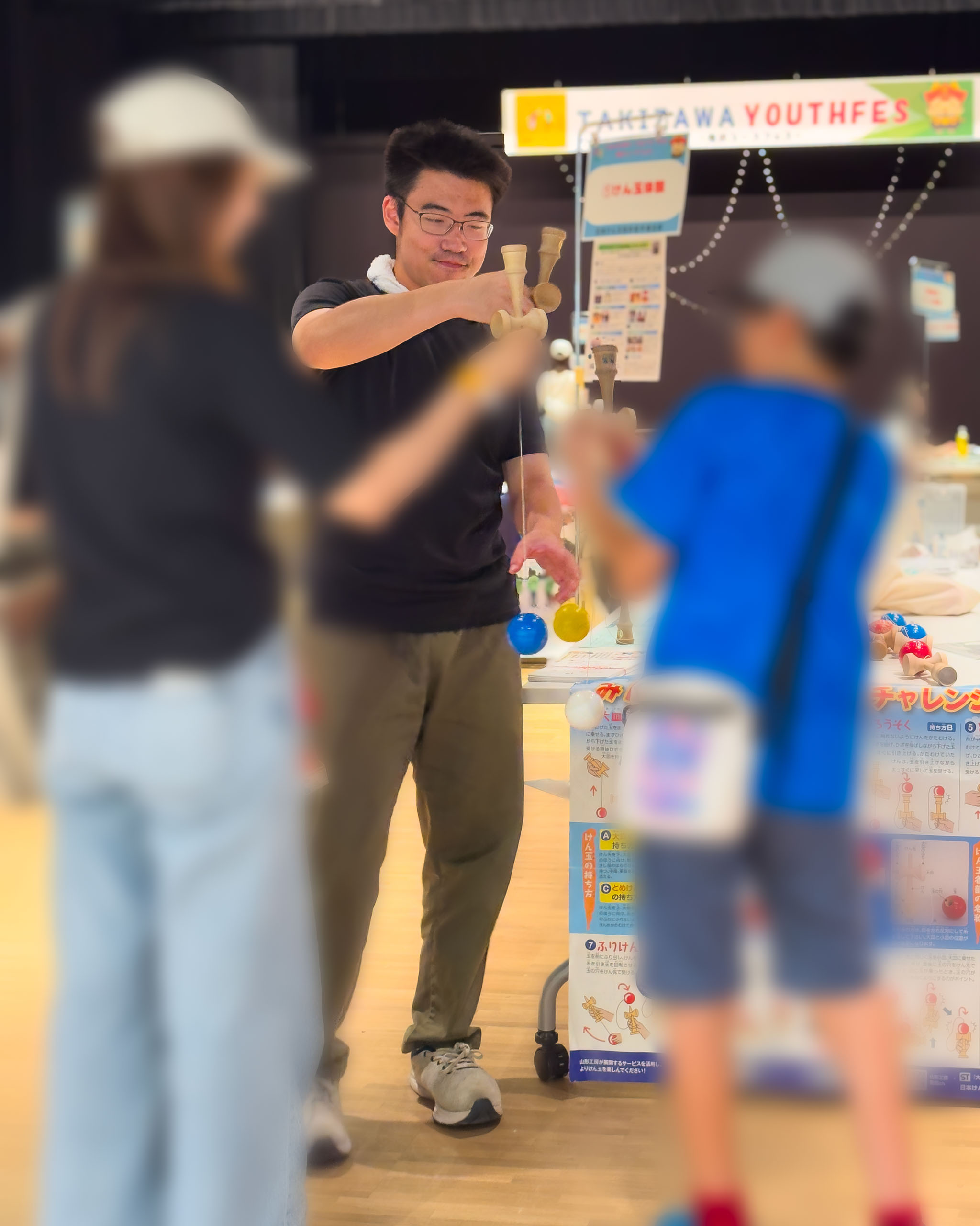 けん玉の技を教わる子ども