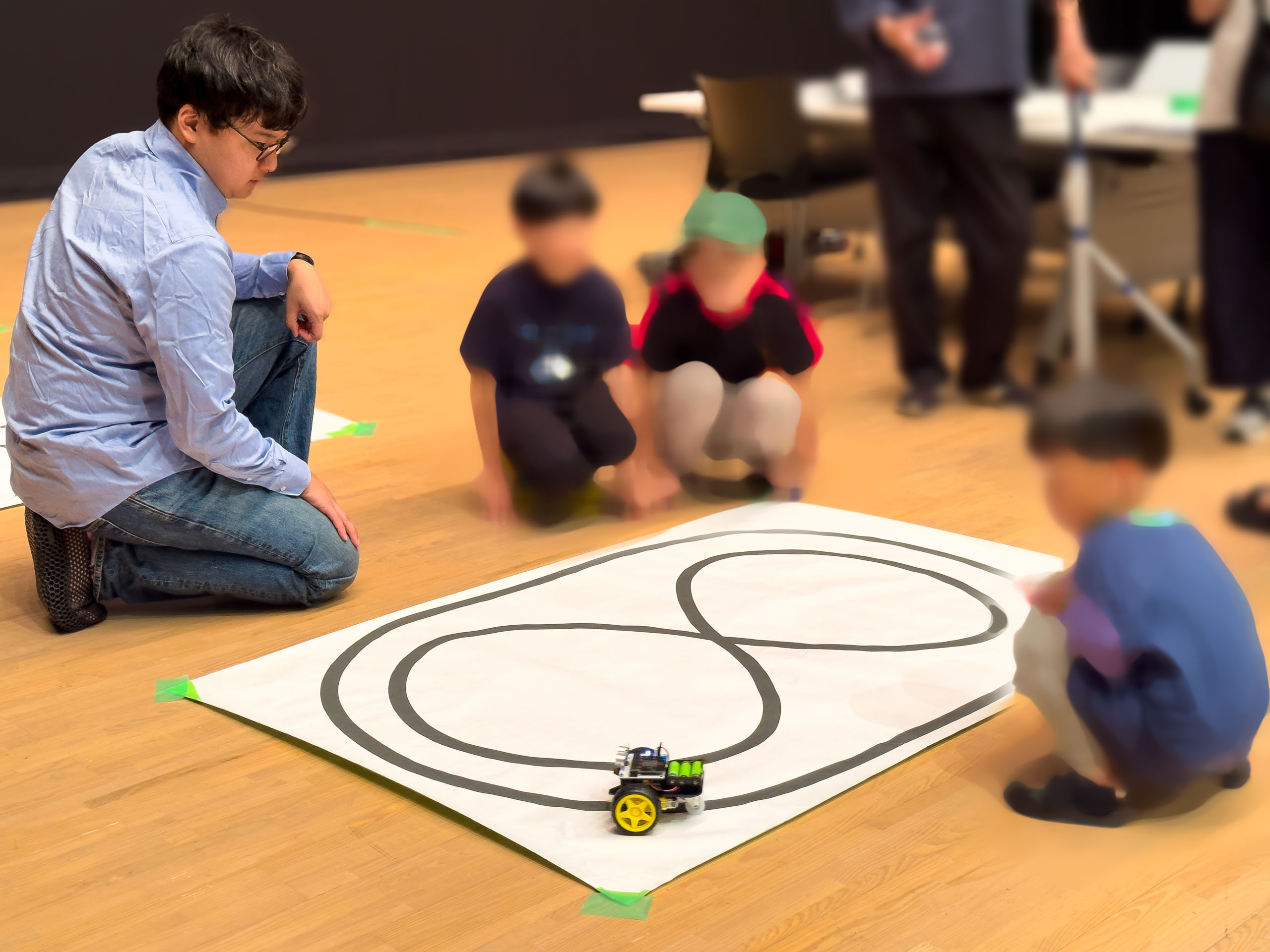 コースの上でロボットカーを走らせる体験
