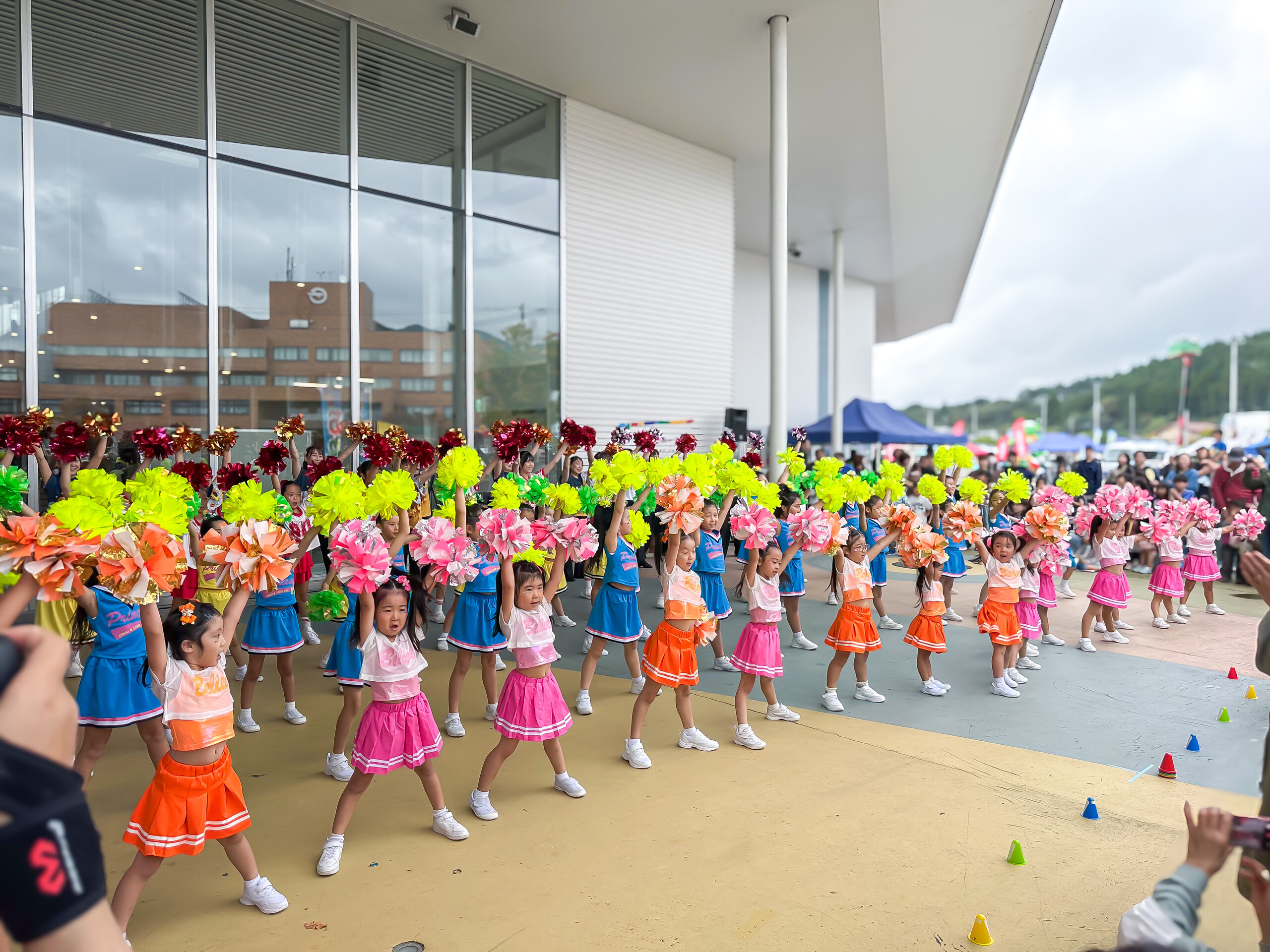 ポンポンを掲げて踊るキッズチア